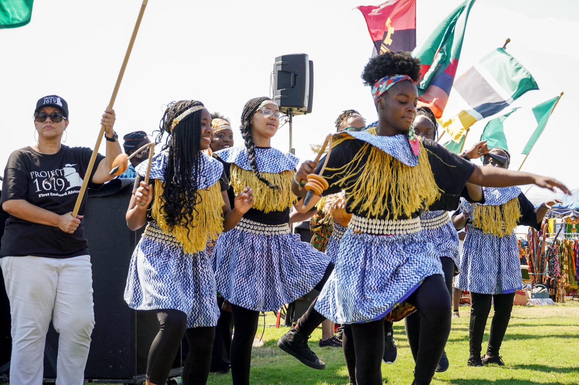 Girls wearing traditional garb dancing at African Landing Day commemoration.