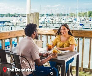 Couple dining at The Deadrise restaurant with views of the boats and marinia.