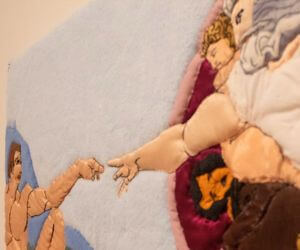 The 'Creation of Adam' recreated using quilting techniques allowing viewers to feel the artwork.