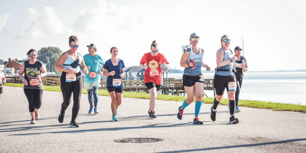 Marathon runners jog past waterfront.