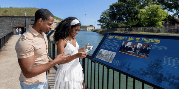 Couple reads historic signage outside a Fort Monroe casemate