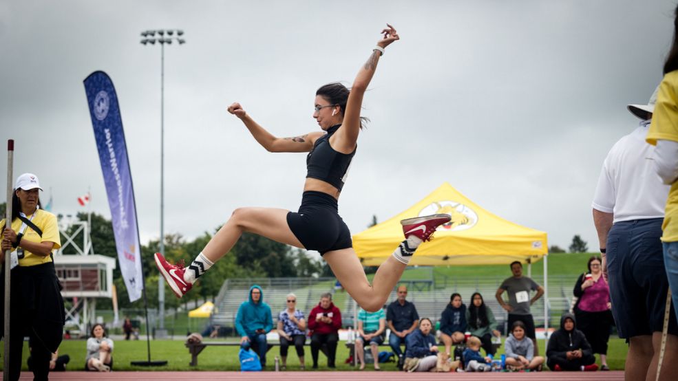 Three men compete in hurdles